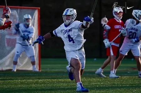 A lacrosse player is running on the field.