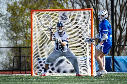 A lacrosse player is ready to catch the ball.