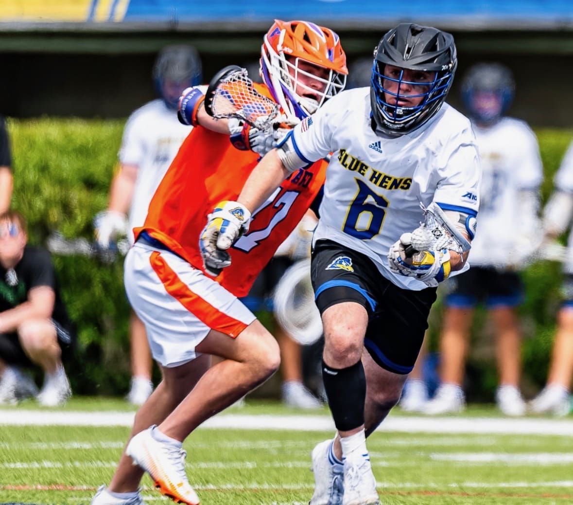 Lacrosse player in white jersey evading defender