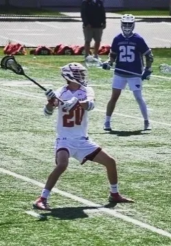 A lacrosse player is getting ready to hit the ball.