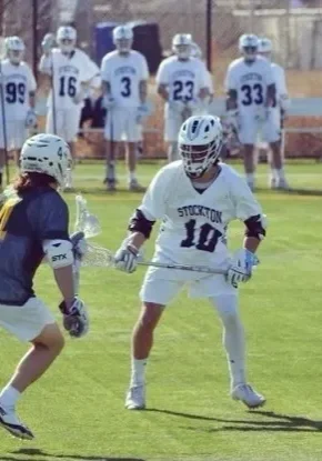 A group of lacrosse players are playing on the field.