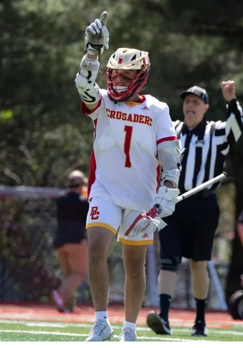 A lacrosse player is waving to the crowd.