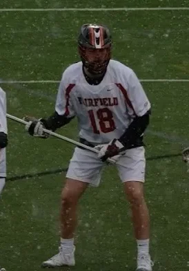 Two lacrosse players in white and red uniforms.